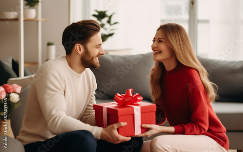 young couple man exchange gifts at home giving presents to each other . valentine holiday or birthday