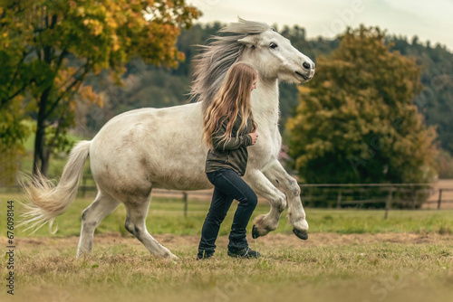 A young woman and her icelandic horse working and cuddle together  equestrian natural horsemanship concept
