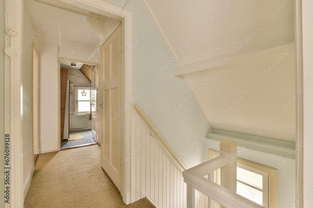 a long hallway with white trim on the walls, and carpeted stairs leading up to an open door that leads to another room a long hallway with white trim on the walls, and carpeted stairs leading up to an open door that leads to another room