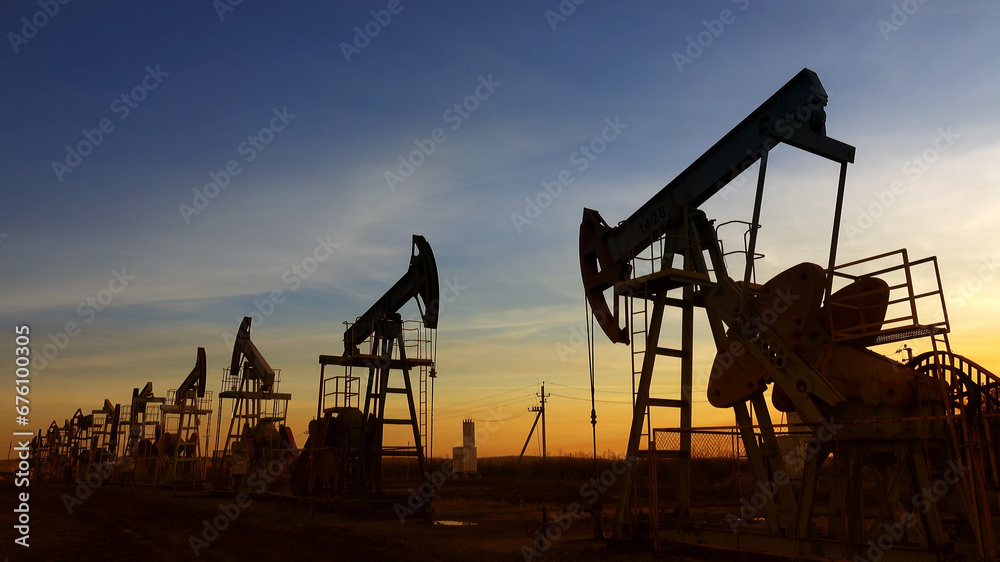 Working oil pumps silhouette against sunset