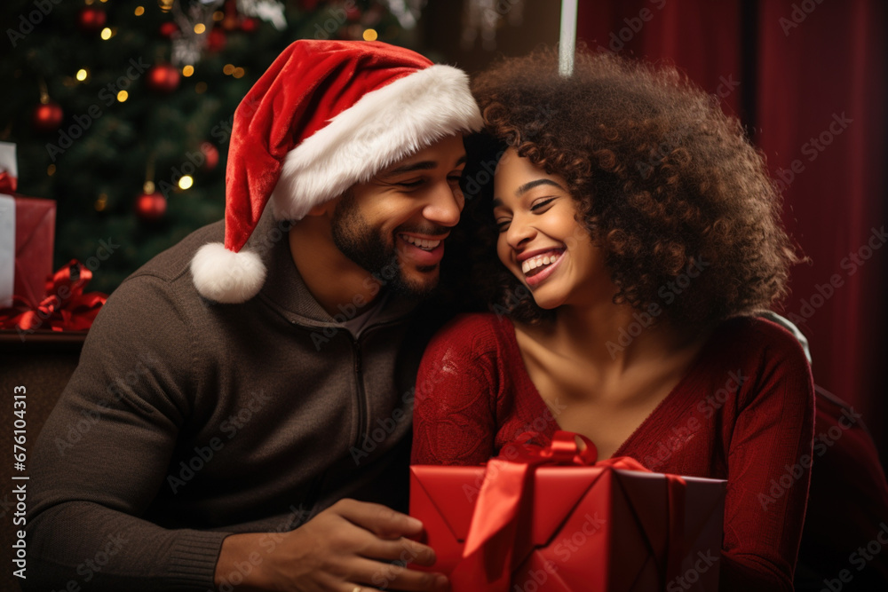 Xmas Christmas holidays concept. Cute African-American happy married family spouses couple husband wife in red Santa's Christmas hats and t-shirt hugging each other celebrating on the ocean sea beach. Xmas Christmas holidays concept. Cute African-American happy married family spouses couple husband wife in red Santa's Christmas hats and t-shirt hugging each other celebrating on the ocean sea beach.
