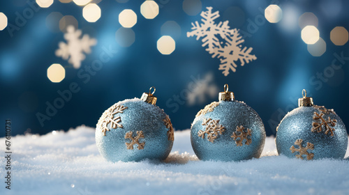 beautiful christmas background with blue and silver christmas balls in front of a bokeh of snowflakes