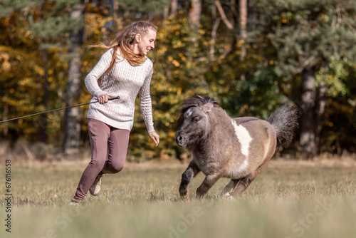 Natural Horsemanship concept: Cute portrait of a young woman and her pony working and interacting together © Annabell Gsödl