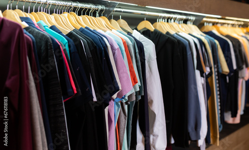 Men clothing shop, casual clothes on hangers and shelves in apparel store