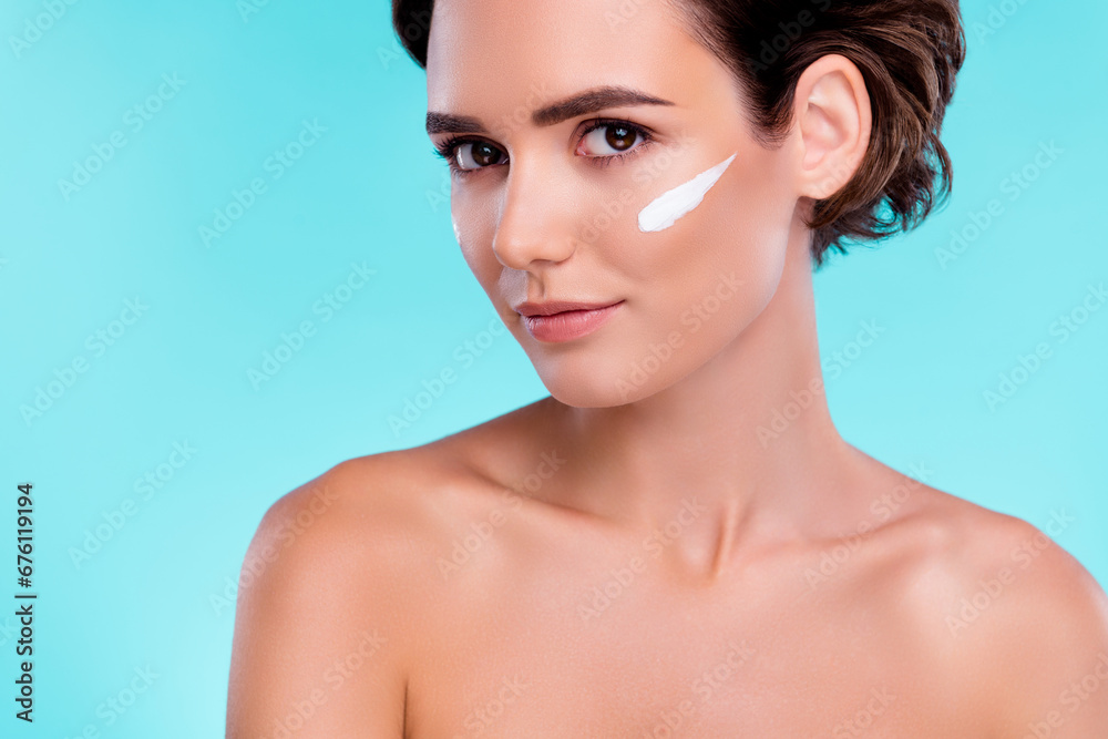 Photo of stunning gorgeous lady applying cream lotion on face for soft skin rejuvenation over blue background Photo of stunning gorgeous lady applying cream lotion on face for soft skin rejuvenation over blue background
