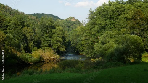 Castle Seen from a Beautiful Lush Forest Valley Wilderness in Europe in September photo