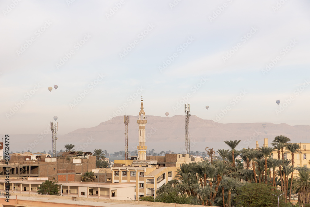 minaret skyline in village in Luxor, Egypt with mountains in the background