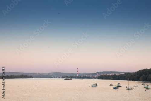 Zemun Quay (Zemunski Kej) in Belgrade, Serbia, on the Danube river, seen in autumn, at sunset. Boats can be seen in front, and Belgrade center in background photo