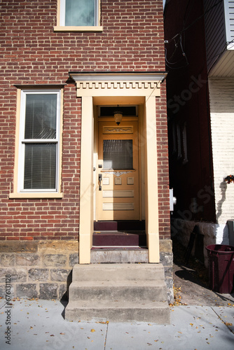 front door to a brick house. concrete steps at the entrance.