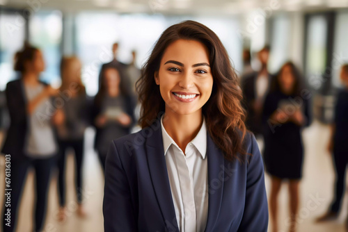 Portrait of a smartly dressed smiling young businesswoman standing in her office with her colleagues attractive young female manager wearing shirts and jacket © RCH Photographic