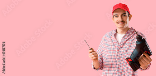 Young man holding drill and...