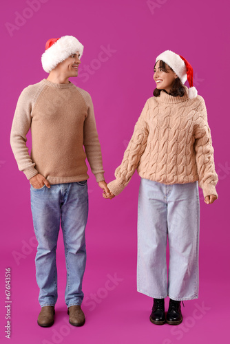 Happy young couple in santa...