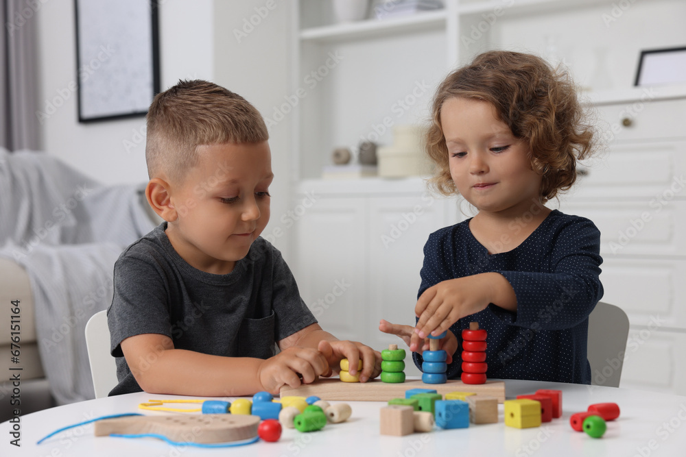 Fototapeta premium Motor skills development. Little kids playing with stacking and counting game at table indoors
