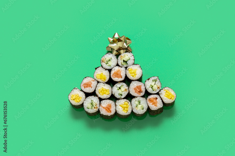 Christmas tree made of tasty sushi rolls on green background Christmas tree made of tasty sushi rolls on green background