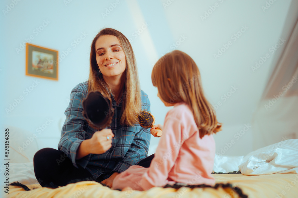 
Girl Combs her Mom with a Hairbrush Playing Haidressing Game
Funny family having fun in a role play activity
