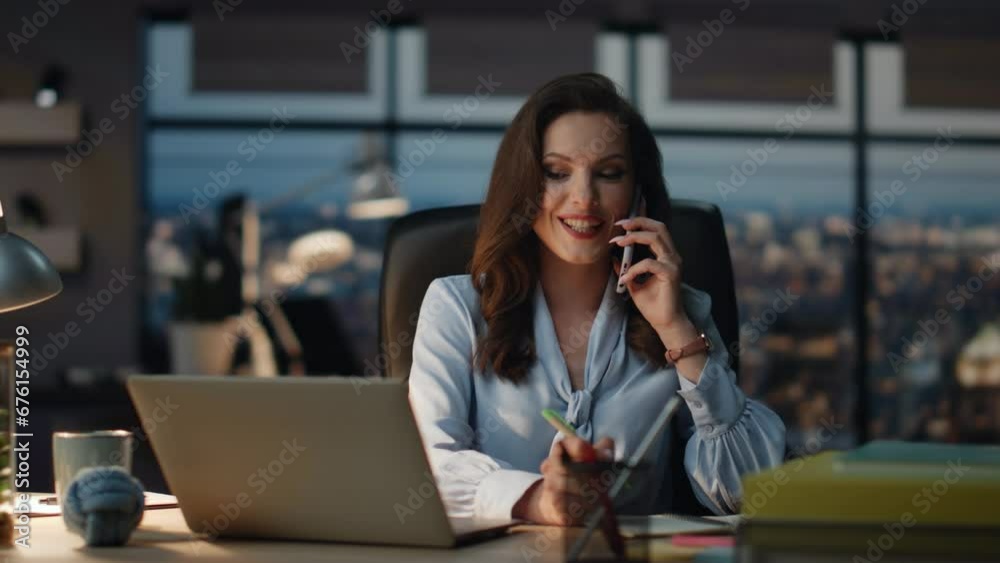 Confident lady talking mobile phone call at evening view office. Manager writing Confident lady talking mobile phone call at evening view office. Manager writing