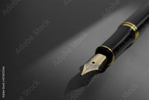 Stylish fountain pen on light grey textured table, closeup. Space for text