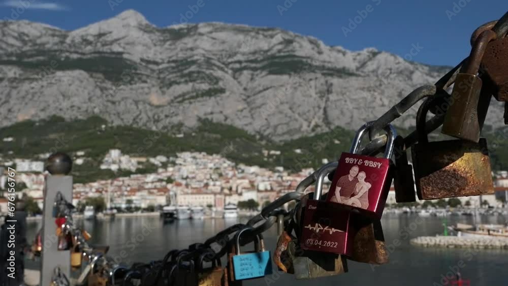 Love locks and view of seaside town by mountains, symbol of couple in love Love locks and view of seaside town by mountains, symbol of couple in love