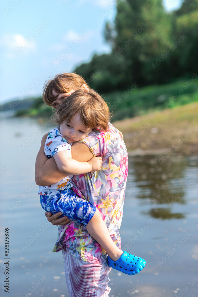 Grandson and grandmother playing on the river bank Grandson and grandmother playing on the river bank
