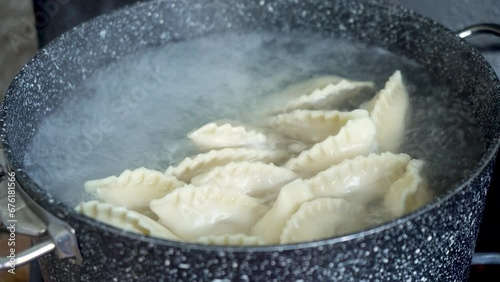 Handmade dumplings, vareniki are boiled in boiling water in a saucepan