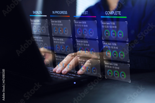 Developer working on laptop computer with kanban board to develop work process and monitoring progression of job status from start to complete