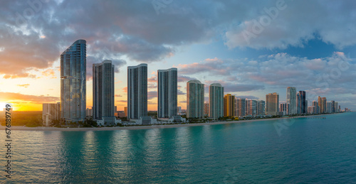 Aerial view of Sunny Isles Beach city with luxurious highrise hotels and condos on Atlantic ocean shore at sunset. American tourism infrastructure in southern Florida © bilanol