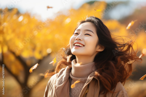 A asian woman breathes calmly looking up enjoying autumn air