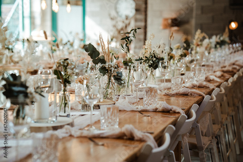 Wedding decoration with flowers and wooden tables and chairs in pastel colors 