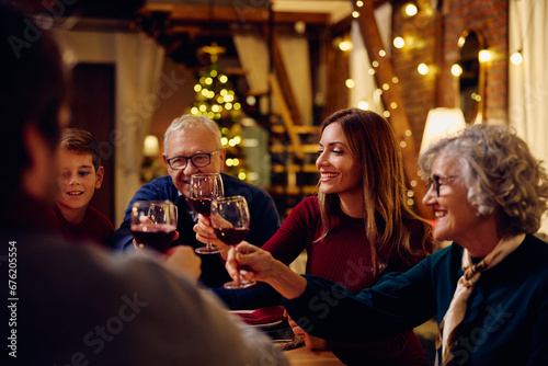 Happy extended family toasting during meal at dining table on Christmas.