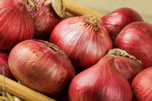 Basket of Red Onions on  wooden background with copy space