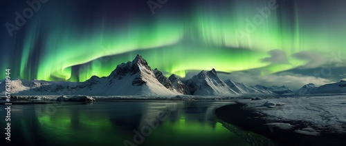 Aurora borealis in Iceland with snow covered mountains and reflection © Rudsaphon