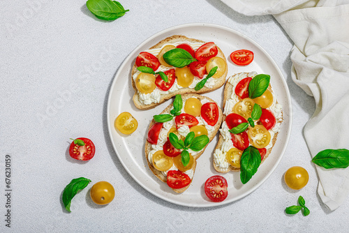 Fresh bread sandwiches with tomato cherry, cream cheese and basil leaves. Morning breakfast concept © FuzullHanum