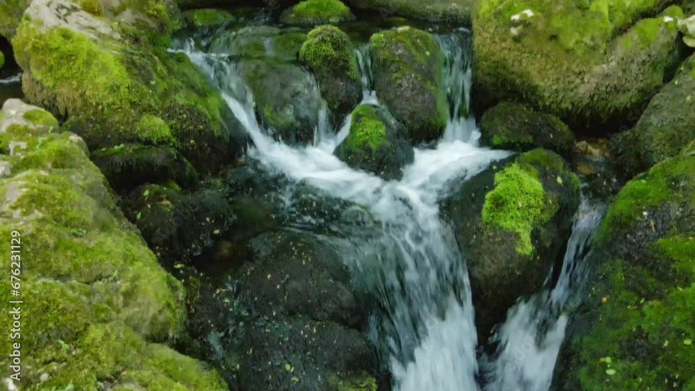 Close-up of water descending over moss-covered rocks in the woods in Serbia Close-up of water descending over moss-covered rocks in the woods in Serbia