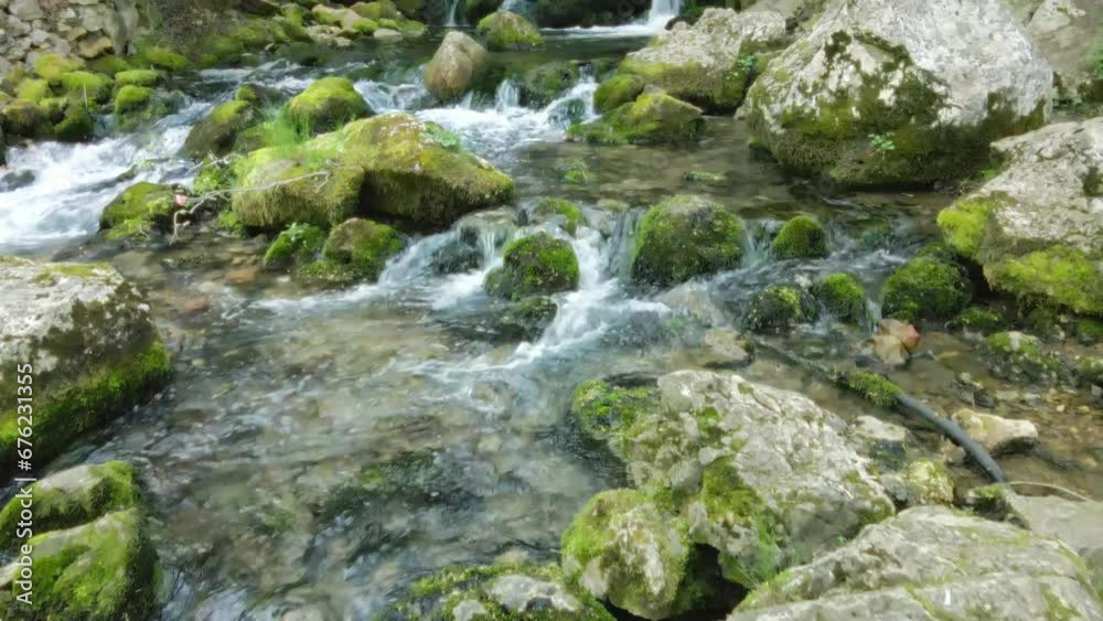 Close-up of water descending over moss-covered rocks in the woods in Serbia Close-up of water descending over moss-covered rocks in the woods in Serbia