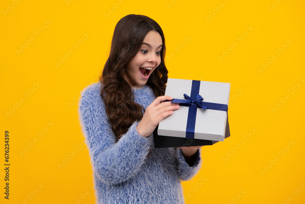 Amazed teenager. Funny kid girl in winter wear holding gift boxes celebrating happy New Year or Christmas. Winter holiday. Excited teen girl. Amazed teenager. Funny kid girl in winter wear holding gift boxes celebrating happy New Year or Christmas. Winter holiday. Excited teen girl.