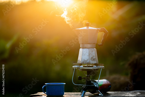Moka pot and smoke, Steam from the coffee pot on fire, In the forest at sunrise in the morning. soft focus. shallow focus effect.