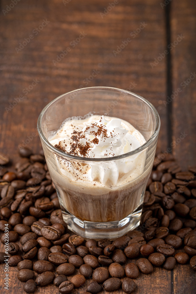 Hot espresso con panna in glass cup on wooden table Hot espresso con panna in glass cup on wooden table