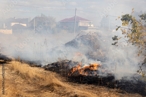 steppe fires during severe drought completely destroy fields. Disaster causes regular damage to environment and economy of region. The fire threatens residential buildings. Residents extinguish fire