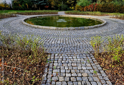 tributary to the pond is slowed down in a cobbled small pond which serves as a paddling pool for children. the overflow oxygenates the water to the fish. park landscape, formal garden photo