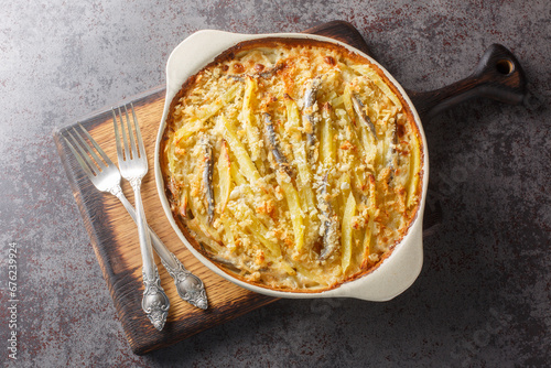 Obraz na płótnie Janssons frestelse or Jansson's temptation is a creamy potato casserole traditionally served at Christmas in Sweden closeup on the baking dish on the table. Horizontal top view from above w salonie