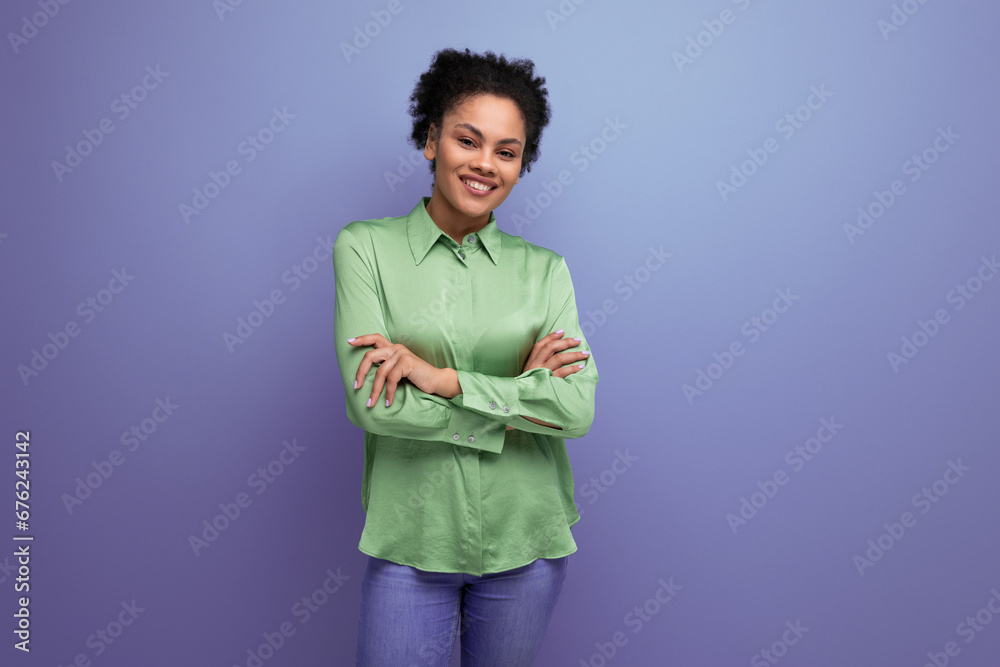 young brunette hispanic woman with curly hair dressed in a green blouse on a background with copy space. people lifestyle concept young brunette hispanic woman with curly hair dressed in a green blouse on a background with copy space. people lifestyle concept