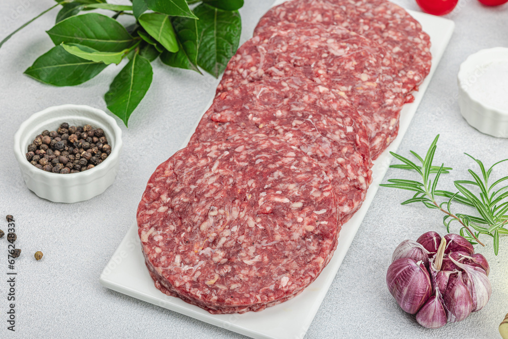 Raw burger patties. Fresh meat cutlets, spices, vegetables, herbs. Homemade American classic Raw burger patties. Fresh meat cutlets, spices, vegetables, herbs. Homemade American classic