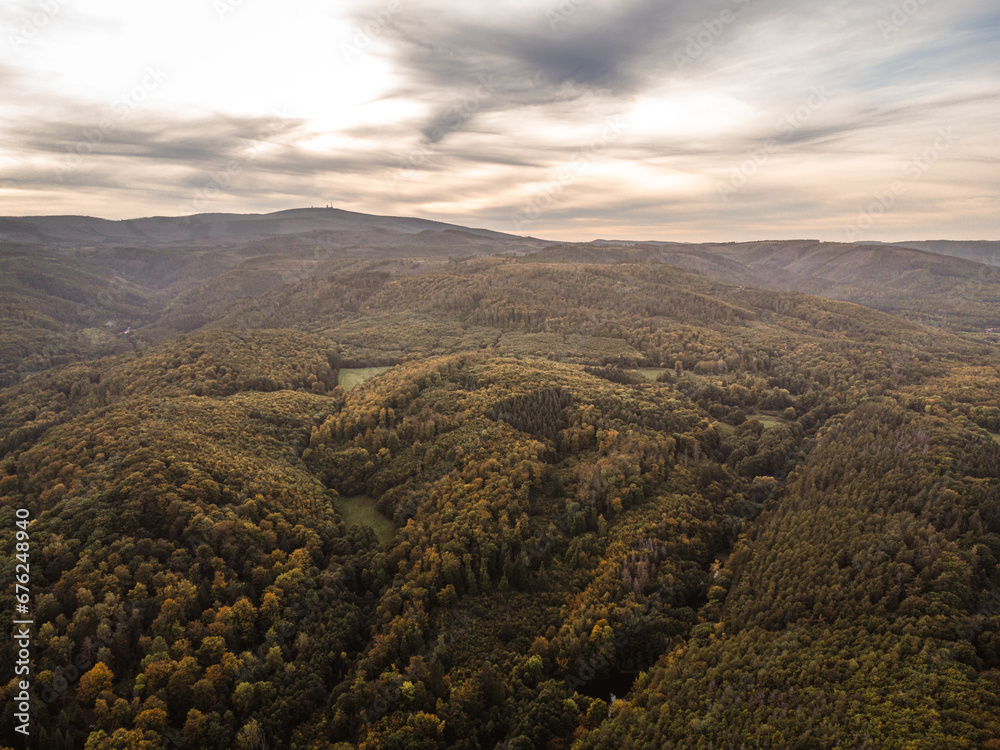 Fototapeta premium Luftaufnahme Brocken und Wälder im Herbst mit Wolken am Himmel