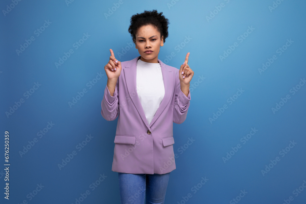 young smart hispanic brunette leader woman with curly hair in a jacket pointing her finger at the advertising space young smart hispanic brunette leader woman with curly hair in a jacket pointing her finger at the advertising space