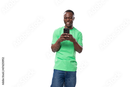 American brunette man with short haircut wearing a light green T-shirt chatting on a mobile phone