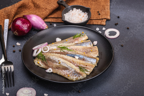 Fillet of pickled marinated sea herring fish with shallots and dill. Cutlery, vintage napkin