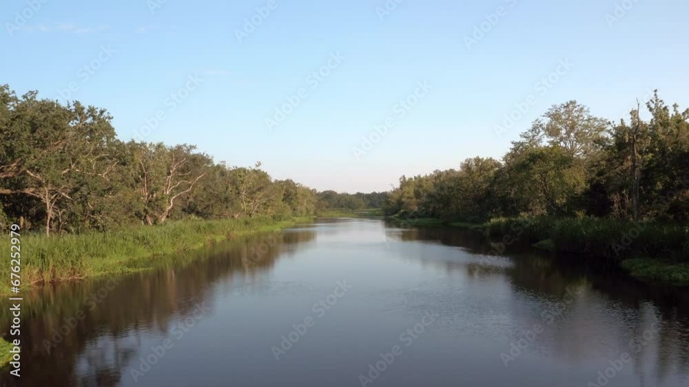 Aerial: Drone Forward Scenic View Of Tranquil Rippled River Amidst Green Plants Against Clear Sky - Bayou, Louisiana Aerial: Drone Forward Scenic View Of Tranquil Rippled River Amidst Green Plants Against Clear Sky - Bayou, Louisiana