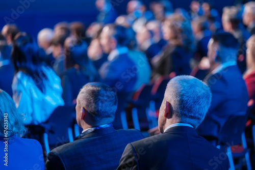 Back view of businessmen attending conference meeting in auditorium at export forum