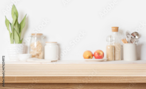 Wooden table background for product display montage with blurred kitchen utensils and food ingredients