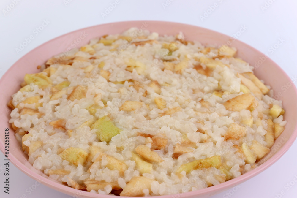 Rice porridge with apples in a bowl close-up. Rice porridge with apples in a bowl close-up.